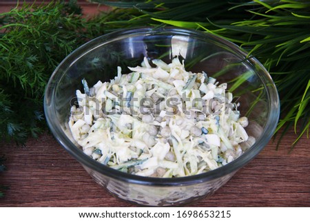 Salad of cabbage, cucumber and canned peas, seasoned with mayonnaise, in a glass transparent Cup