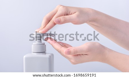 Washing hands. Asian young woman using liquid soap to wash hands, concept of hygiene to protective pandemic coronavirus isolated on gray white background, close up. Royalty-Free Stock Photo #1698659191