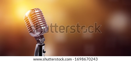 A classic musical microphone on blur colorful background Royalty-Free Stock Photo #1698670243