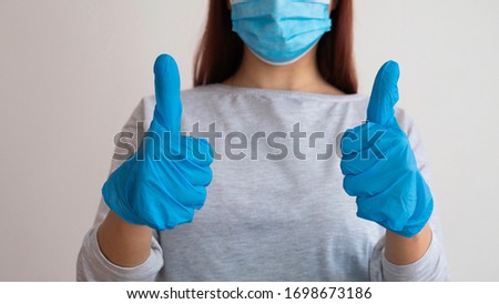 Good job medicine. A woman with gloves and a medical mask gives thumbs up. Support for doctors and nurses. Royalty-Free Stock Photo #1698673186