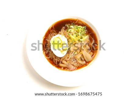 A picture of one rare traditional food from Malaysia call "mee belacan" on white table. A noodle eat together with squid and shrimp paste soup.