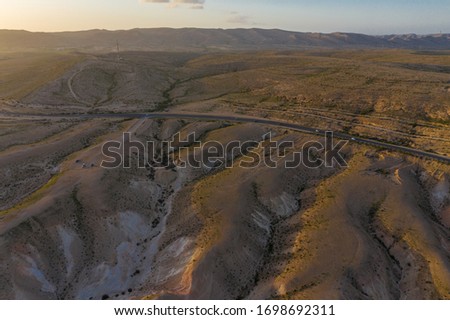 Aerial panoramic spring view of the sunset over the wadi Havarim, Avdat Canyon (Ein Avdat) and kibbutz Sde Boker in the Israel's Negev Desert, Southern Israel. 