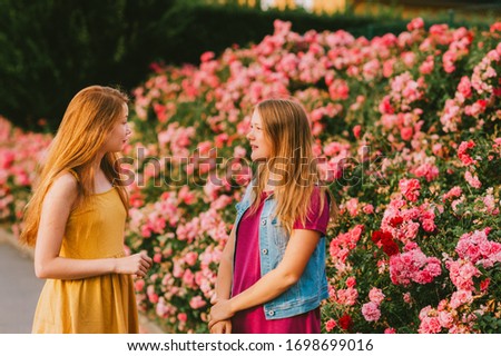 Outdoor portrait of two teen girls talking together outside