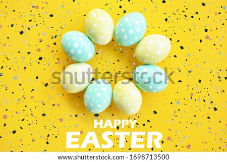 Colorful Easter eggs painted in pastel colors on a yellow background with happy easter text.