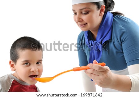 Little boy tasting the food served by female cook isolated on white 