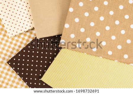 Mix of beige, white and brown cotton fabric. Top view.