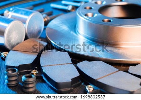 brake parts on dark background  brake pads, disc, brake hose, guides, cylinders Royalty-Free Stock Photo #1698802537