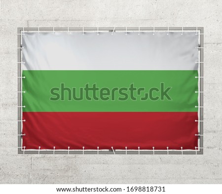 Bulgaria  flag on a tarpaulin that is placed on a concrete wall.