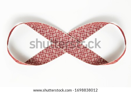 A conceptual image of latvian traditional Lielvarde belt waved in a symbol of eternity depicting infinity of Latvia. Isolated on a white background.