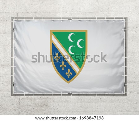 Sandzak flag on a tarpaulin that is placed on a concrete wall