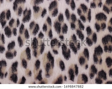 Beautiful leopard faux fur. Texture or background concept. Close up.