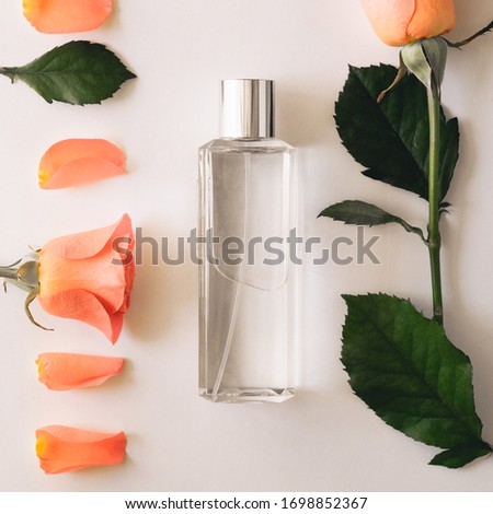 Bottle of perfume with flowers of roses on a white background. Overhead top view, flat lay. Copy space