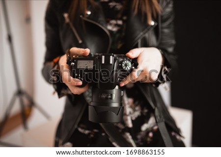 digital camera in hands photographer taking photos ans looking to the camera Royalty-Free Stock Photo #1698863155