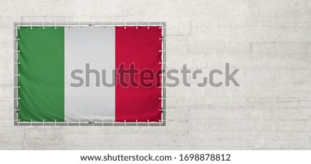 Italy flag on a tarpaulin that is placed on a concrete wall