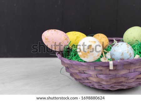 Easter Eggs in the basket with copy space on the black boards background