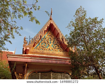 Roof and front of Buddhist temple isolated on blue sky background closeup.Thailand people culture.