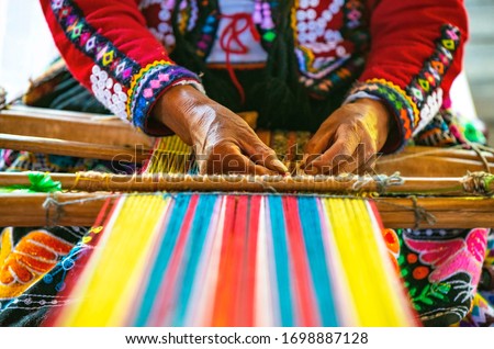 Peruvian indigenous Quechua woman weaving a textile with the traditional techniques in Cusco, Peru. Royalty-Free Stock Photo #1698887128