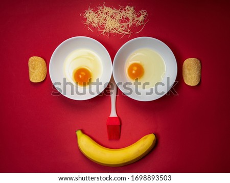Iconic face shape from foods like eggs, cheese, chips, and banana. Still life food