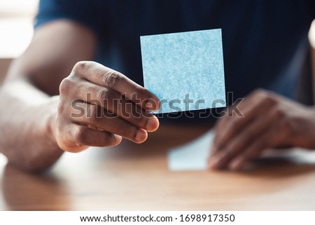Showing blank stickers. Close up of african-american male hands, working in office. Concept of business, finance, job, online shopping or sales. Copyspace for advertising. Education, freelance.