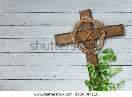 Christian wooden cross and crown of thorns on the desk
