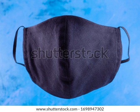 Protective mask. Antivirus mask made from cotton. Black face mask during a pandemic virus COVID-19. Face mask on a blue background