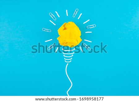Crumpled yellow paper lamp on a blue background. New idea, innovation and concept of solutions. Business idea. Business concept. Recovery, business revitalization.