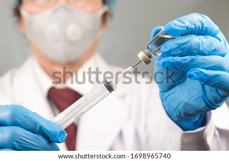 Coronavirus (COVID 19) Vaccine and syringe injection hand hold Doctor or nurse on gray background. 
Protect immunization and treatment from corona virus infection ,nCoV 2019 concept.