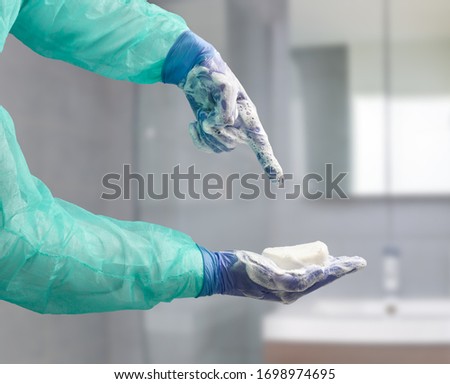 Medical worker holding soap and pointing towards it in the bathroom