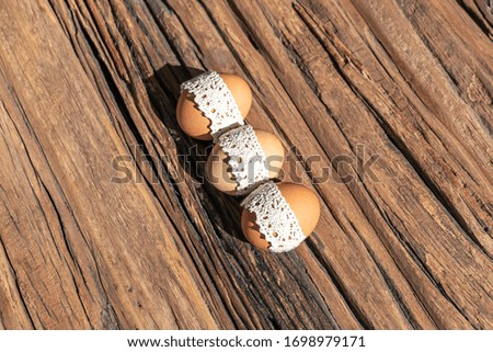 Creative photo with easter rustic eggs on a vintage wooden background and hard shadows.