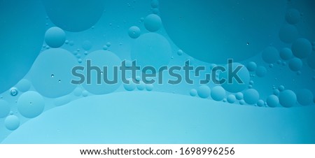 oil with bubbles on dark blue background. Abstract space background. Soft selective focus. macro of oil drops on water surface. copy space. air bubbles in water, horizontal format, social media ready