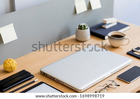 Stylish flat lay business composition on the wooden desk with laptop, tablet, mobile screen, cacti, cup of coffee, notes and office supplies in modern concept.