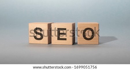 Wooden cubes with word SEO on blue table