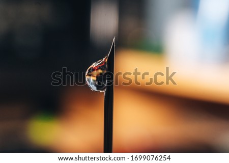 Water droplet on the top of the needle