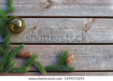 Wooden plank background with green branches of a Christmas tree in the corner. Copy space for your text.