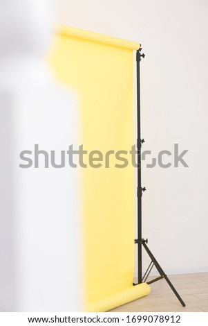 yellow paper background on stand with laminate flooring in studio