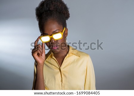 African American woman with yellow sunglasses and whited out eyes. Abstract eyeware image.