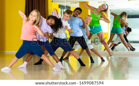 Cheerful little children studying modern style dance in class Royalty-Free Stock Photo #1699087594