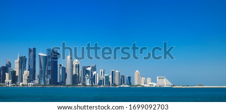 Morning panoramic cityscape view of Doha skyscrapers and towers from Persian Gulf. Futuristic skyline of financial commercial district in Qatar on horizon