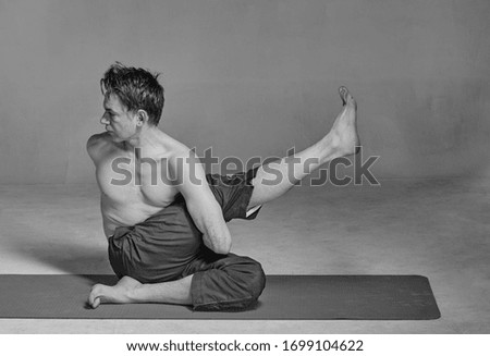Young handsome man performing yoga exercises