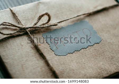 a photo book Packed in paper with silence on a gray background with a package of Kraft paper with a flash card is the final product of the photographer's work