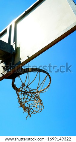 Basket with ruined net seen from below in the morning sun. conceptual image for finish line, goal