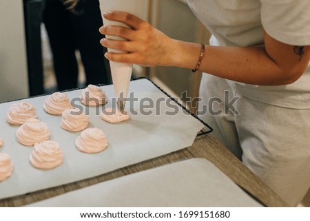 Homemade pink marshmallows on baking paper background on the kitchen