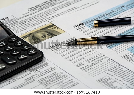 Individual income tax return form, pen and calculator on desk. Tax time Royalty-Free Stock Photo #1699169410