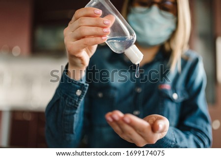 Coronavirus. Sanitizer gel. Business woman working in home, quarantine. Cleaning hands antibacterial gel to eliminate germs. Stay at home. Girl learns, using laptop. Freelance. Prevent Covid-19 virus. Royalty-Free Stock Photo #1699174075