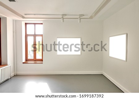 Minimalistic white gallery interior with two white empty frames