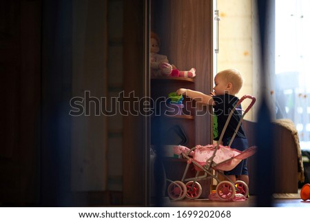 Side view of silhouette baby boy standing by cabinet in dark room at home