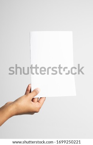Woman of color holding an a5 or half letter-sized blank mockup.