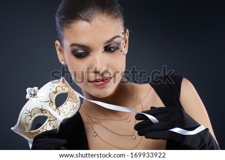 Portrait of smart woman in fancy makeup with carnival mask and gloves.