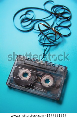 Cassette tape on a blue background with the tape twisted