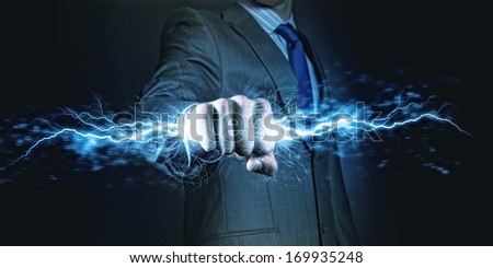 Businessman holding lightning in fist. Power and control Royalty-Free Stock Photo #169935248